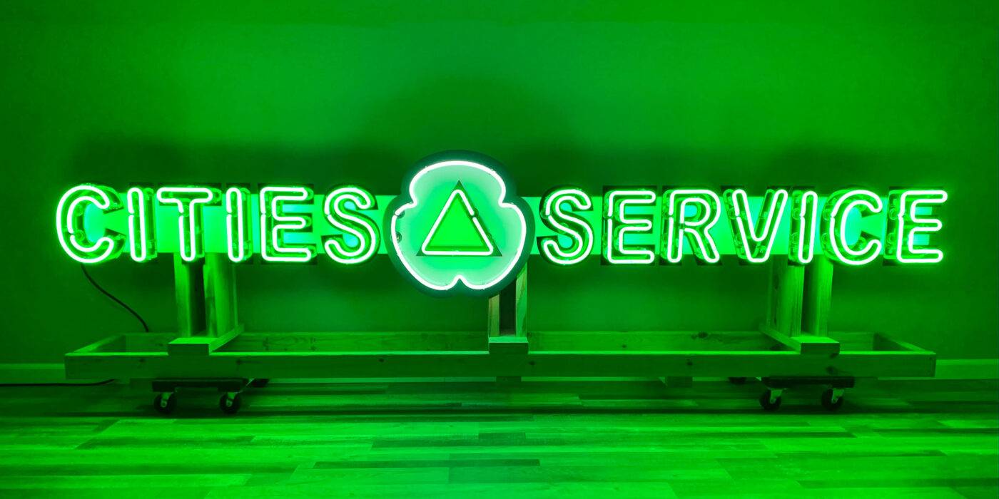 Neon road green cities service sign lit on