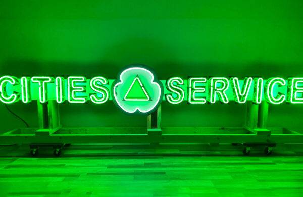 Neon road green cities service sign lit on